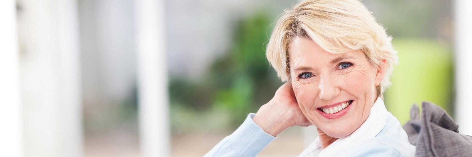 Older woman smiling after getting Invisalign clear braces at Middletown, NJ