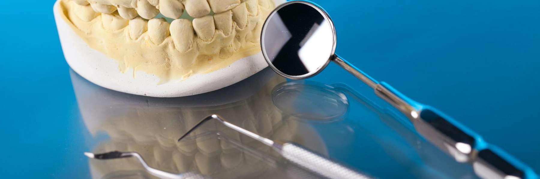 Dental model of human teeth with professional dental tools arranged for examination or treatment