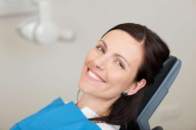 Smiling woman looking relieved and confident after successful treatment for bleeding gums