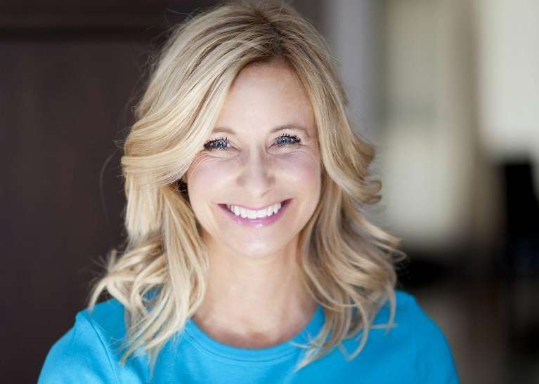 Confident woman smiling brightly, showcasing her dental crowns.