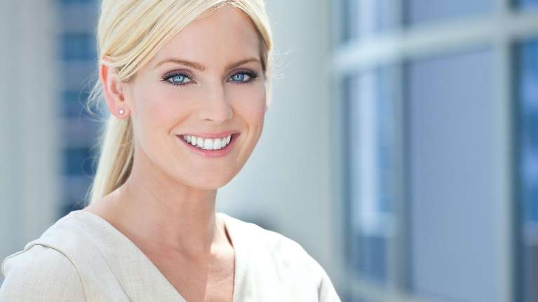 Patient smiling after getting dental crowns from Middletown Dental