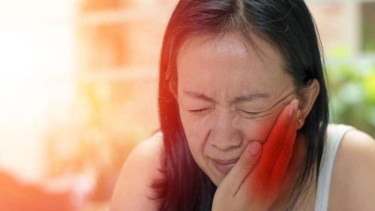 Woman's dental pain highlights urgency of fixing cracked/broken teeth promptly.